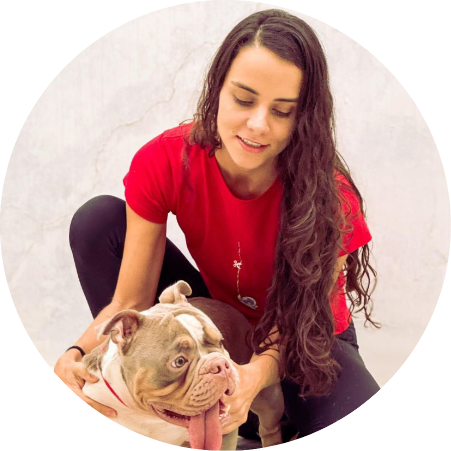 Aline Gutierrez sorrindo enquanto cuida de um cão bulldog